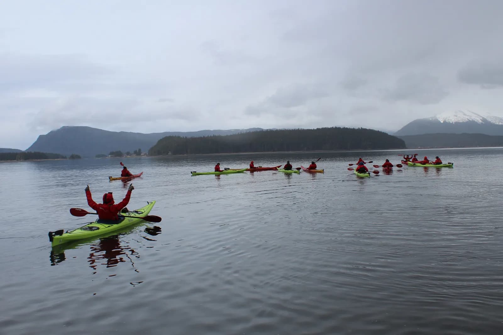 Travelers wearing weatherproof layers on an Alaska kayak excursion